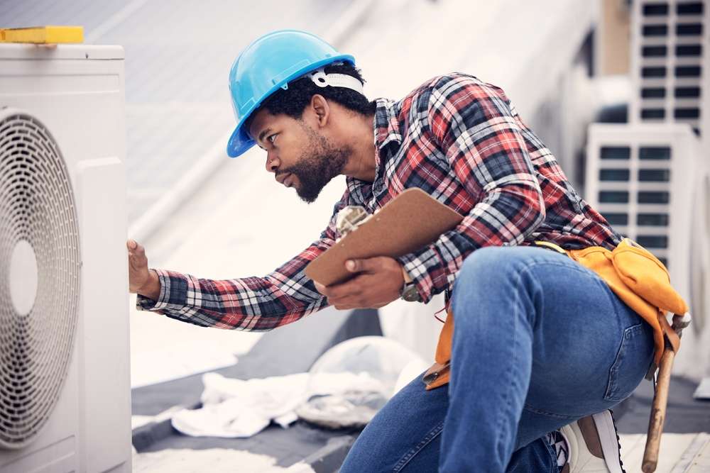 african american hvac technician checking the hvac system