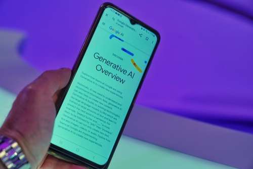 A person holds a smartphone displaying a webpage titled “Generative AI Overview” against a blurred purple background. The screen shows text and a partial Google logo at the top.